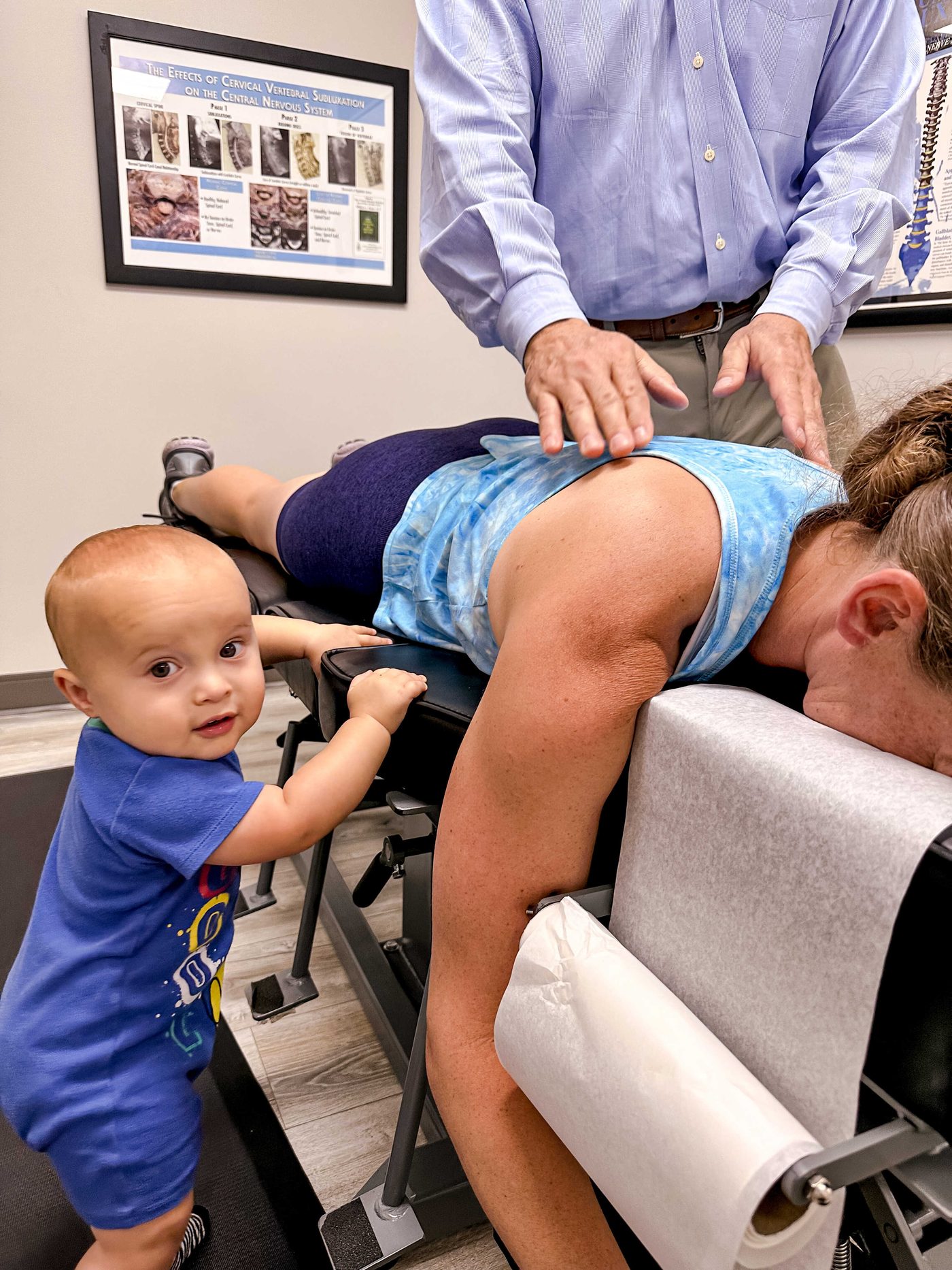 A baby watches Dr. Dan adjust his mother